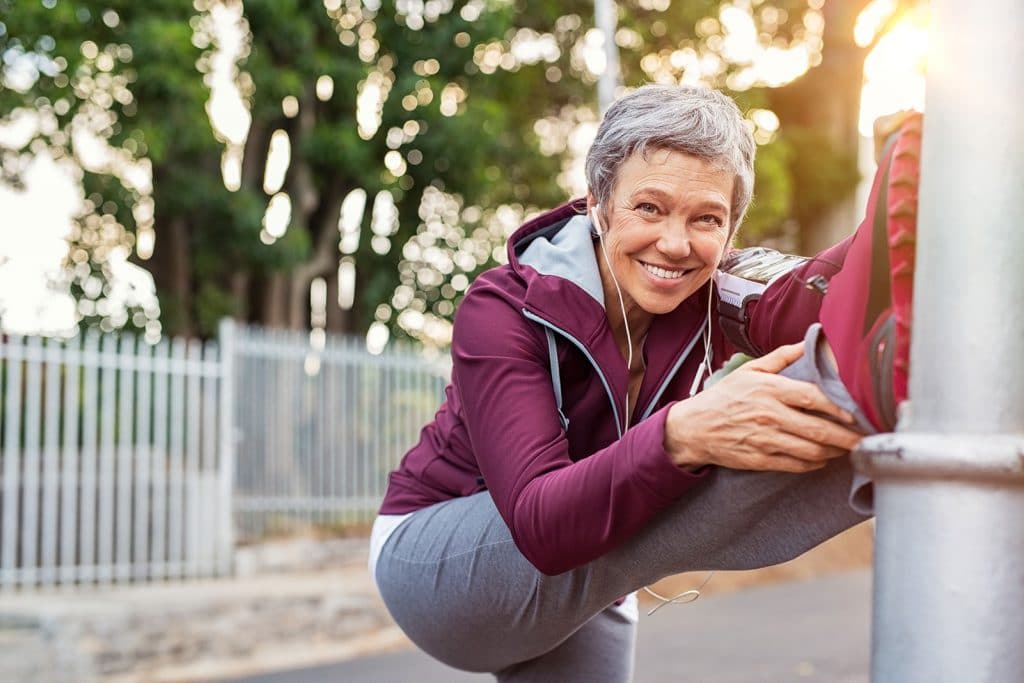 Older athletic woman stretching legs